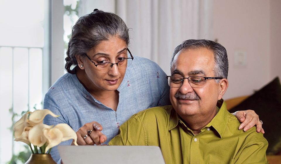 An older couple looking at options on a computer.