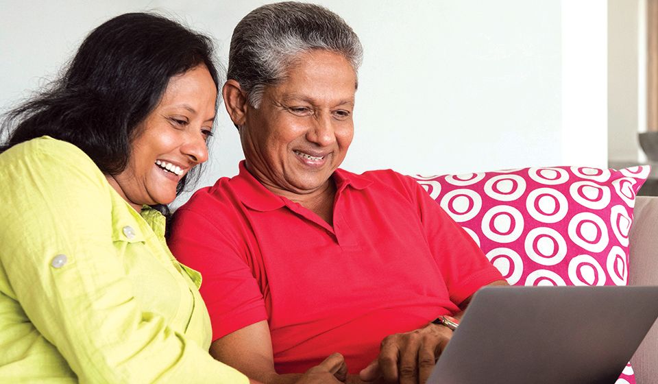 Two people at home looking at a laptop screen
