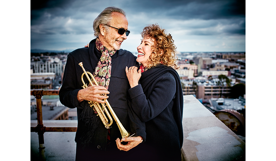 Photo of Herb Alpert, holding a trumpet, and Lani Hall
