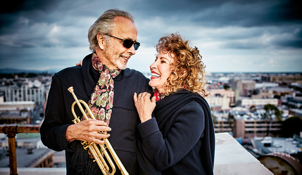 Photo of Herb Alpert, holding a trumpet, and Lani Hall