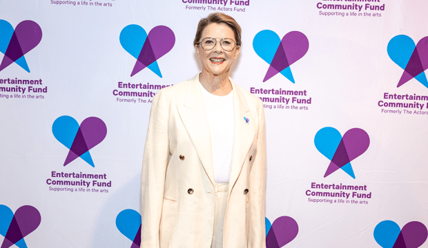Annette Bening stands in front of a step and repeat with the Fund's logo